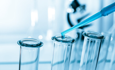 Pipette adding fluid to one of several test tubes .