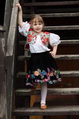 Little girl in traditional costume on the stairs