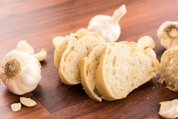fresh baked loaf of bread with whole cloves of roasted garlic