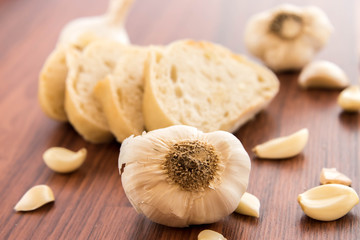 fresh baked loaf of bread with whole cloves of roasted garlic