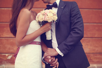Bride and groom holding hands in the city