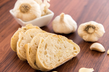 fresh baked loaf of bread with whole cloves of roasted garlic