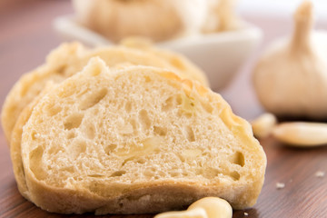 fresh baked loaf of bread with whole cloves of roasted garlic