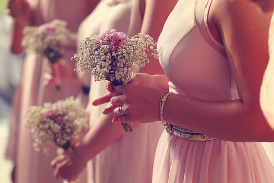 Hands of bridesmaid holding a beautiful gypsophila bouquet