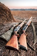 Foto auf Leinwand Hunting shotguns on haystack, soft focus on shutgun butt © splendens