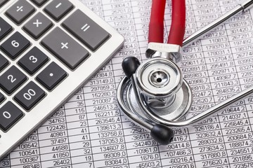 Health. Stethoscope and calculator on document with digits