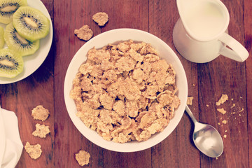 cereals in white bowl and kiwi