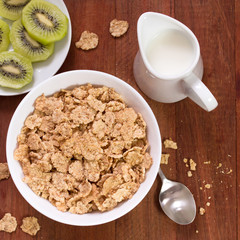 cereals in white bowl, milk and kiwi