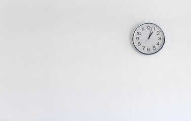 Round metal clock on white wall