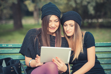 young couple beautiful women girls autumn using tablet