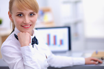 Portrait of  businesswoman sitting at  desk with a laptop