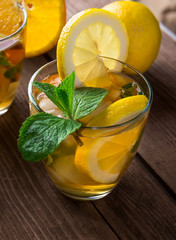 Lemonade with fresh lemon and mint on wooden background