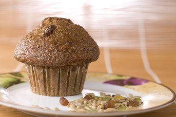 Bran and Raisin Muffin with Mixed Nuts on a Plate