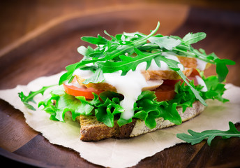 Rye toast with green leaf, tomato and chicken