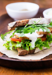 Rye toast sandwich with green leaf, tomato and chicken