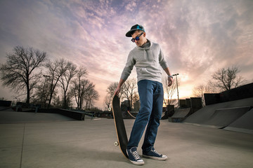 Cool teenage boy with skateboard in the skate park © bokan