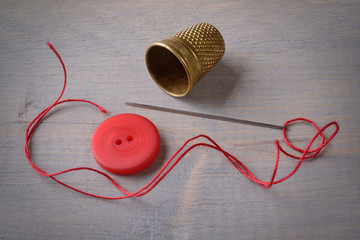 Button, needle, thread and thimble