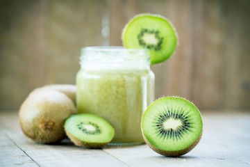 Fototapeta na wymiar Piece of kiwi on kiwi juice background