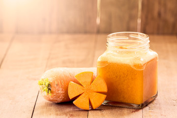 Fototapeta na wymiar Sweet orange color of carrot juice blended on wooden background