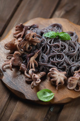 Close-up of octopuses with black rice noodles, selective focus