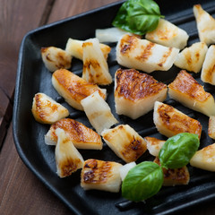 Roasted pineapple slices with green basil on a grill, close-up