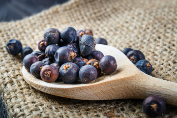 juniper berries on old wooden spoon
