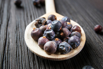 juniper berries on old wooden spoon