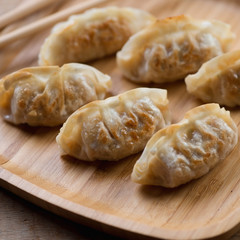 Close-up of gyoza dumplings on a bamboo tray, selective focus