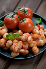 Close-up of italian gnocchi with tomato sauce and green basil