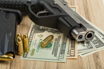 Obraz premium gun with bullet on US dollar banknotes