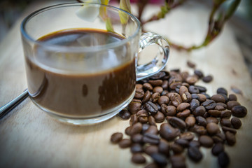 Cup of coffee with coffee beans on a beautiful flower.