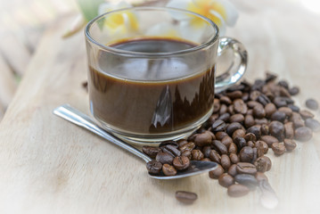 Cup of coffee with coffee beans on a beautiful flower.
