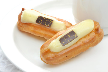 Zwei kleine Eclairs mit Füllung auf dem weissen Teller