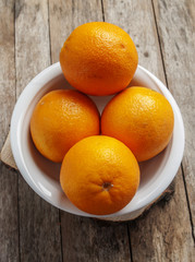 orange in white plate on wooden background