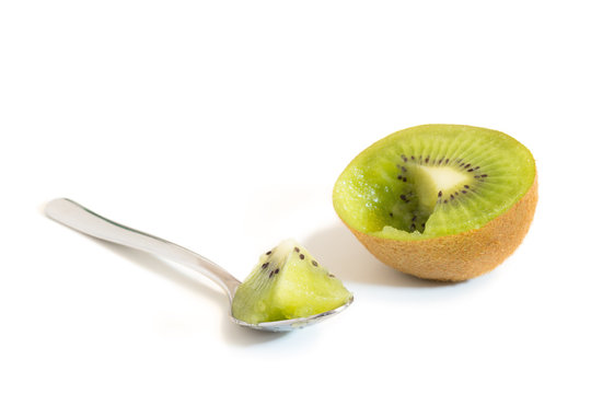 A sliced kiwifruit and spoon with a piece of kiwifruit isolated