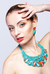 Beautiful blonde woman in bijouterie  on grey background