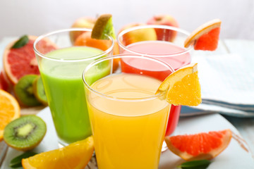 Fresh juices with fruits on wooden table