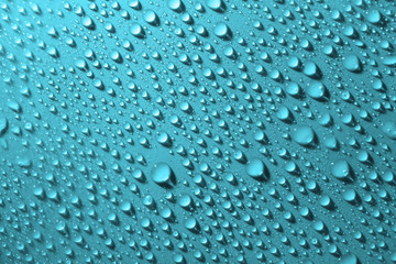 Water drops on glass on green background