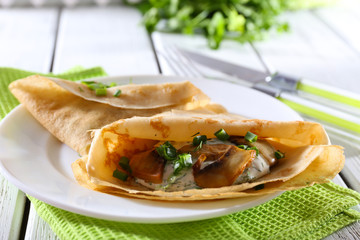 Pancakes with creamy mushrooms and greens in plate