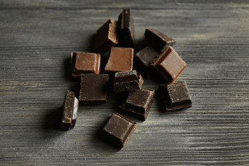 Pieces of chocolate on wooden background