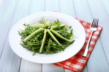Plate of green salad with cucumber, arugula and rosemary