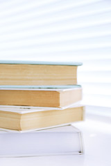 Books on white windowsill, close up