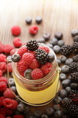 different berries in a basket on a wooden table