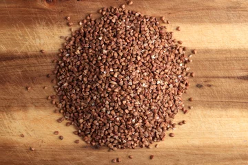 Poster Grains of buckwheat on the kitchen board © sergiymolchenko