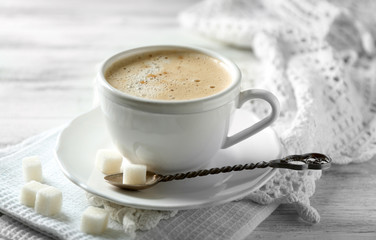 Cup of latte on wooden table, on light background