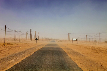 Fototapeta premium wind blowing across the desert sand road, Sahara, Morocco