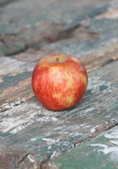 Forgotten red apple on a wooden table