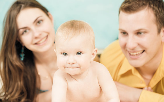 little boy portrait with parents on background