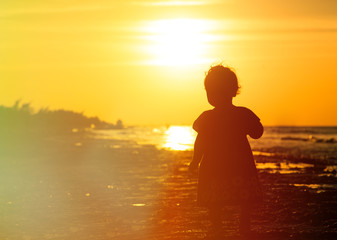 little girl walking at sunset beach