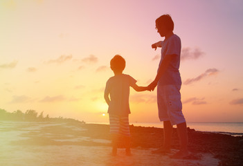 Fototapeta premium father and son at sunset beach
